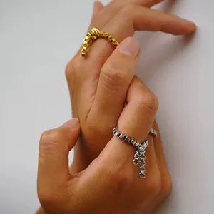 Detaillierte Nahaufnahme eines minimalistischen Kettenrings mit feiner Metallquaste für Damen