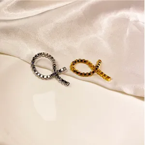 Detailansicht minimalistischer Kettengliederringe in Gold und Silber auf Seidenhintergrund