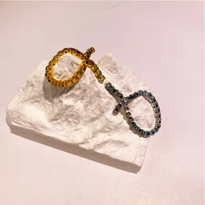 Detailaufnahme von minimalistischen Gold- und Silberkettenringen auf einem Felsständer