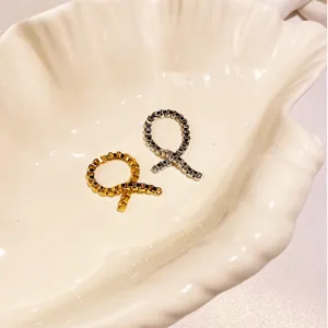Detailansicht von Gold- und Silber-Kettenknotenringen in einer Muschelschale