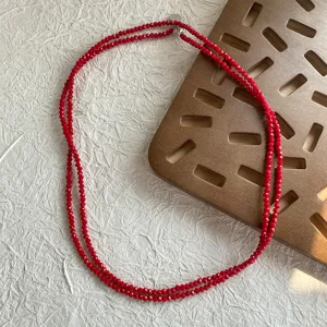 Dettaglio di un elegante collana a due fili di perle di spinello rosso sfaccettate