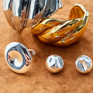 Nahaufnahme von glänzenden goldenen und silbernen Ringen und Ohrringen mit Textur.