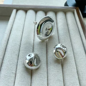 Makro-Detailansicht der glänzend reflektierenden Oberfläche von minimalistischem Silberschmuck