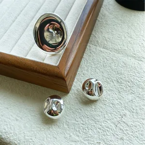 Detailansicht eines hochglanzpolierten silbernen Rings und Ohrringsatzes auf Schmucktablett