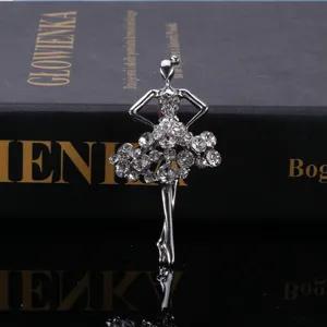 Dettaglio della spilla ballerina in argento con strass scintillanti su un libro