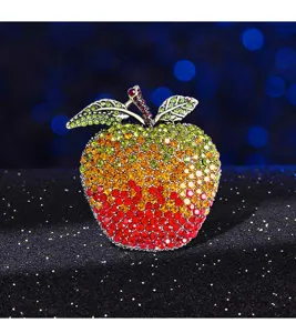 Close-up of apple brooch featuring a gradient of green, yellow, and red rhinestones