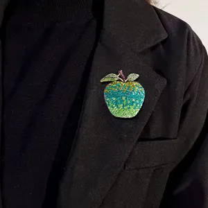 Elegant apple-shaped rhinestone brooch pinned on a classic black blazer lapel