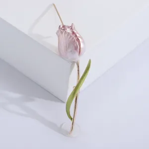 Close-up of an elegant pink enamel tulip brooch featuring a golden stem and green leaf detail