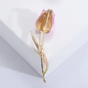 Detail view of the back of an enamel flower brooch with secure pin clasp mechanism.