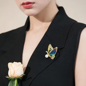 Detailweergave van een elegante emaille vlinderbroche met strass op een zwart revers