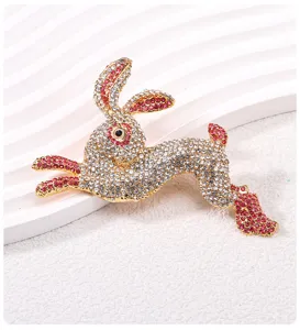 Detailed macro view of a sparkling gold-plated rabbit brooch with pink and white rhinestones