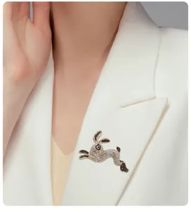 Close-up of a sparkling crystal rabbit brooch pinned on a white elegant blazer lapel