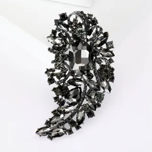 Primer plano de un broche vintage de cristal ahumado con pedrería negra y acabado oscuro