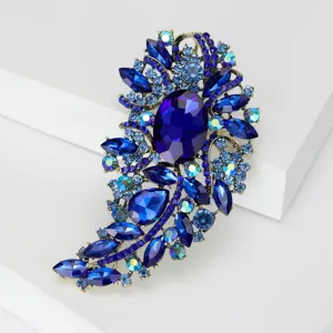 Vista detallada de un broche vintage de cristal azul con detalles de pedrería brillante