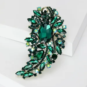 Primer plano de un broche vintage de cristal verde esmeralda con diamantes de imitación