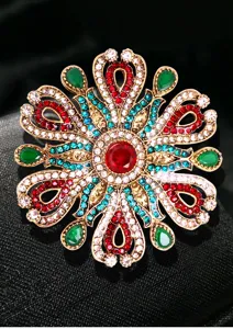 Vue détaillée de la broche de style baroque avec strass colorés et gemme rouge centrale