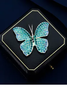 Macro di una spilla a farfalla di strass scintillanti su una scatola nera.