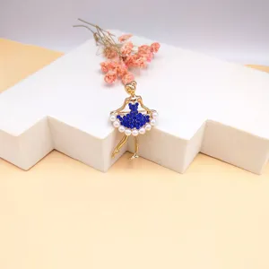 Vista dettagliata di una spilla ballerina con strass blu su un elegante base bianca.