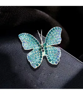 Vista macro dettagliata di un'elegante spilla a farfalla con strass blu e verdi