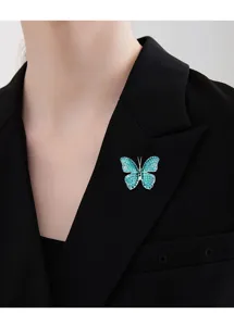 Splendida spilla a farfalla con strass blu e verdi appuntata su un blazer nero