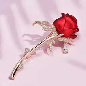 Detail view of an elegant red rose brooch with rose gold finish and pavé crystals