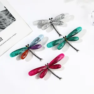 Macro view showing the detailed brushed texture on acrylic dragonfly brooch wings.