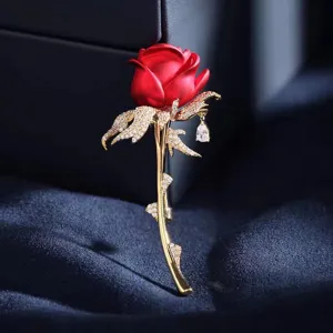 Detailed macro view of elegant red rose brooch with crystal leaves and a teardrop pendant