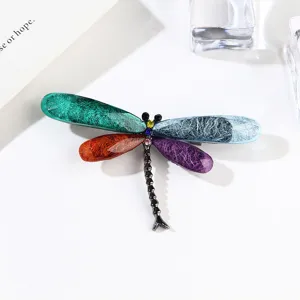 Detailed view of colorful acrylic resin dragonfly brooch with brushed texture wings.