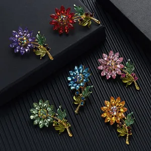 Collectie van zes kleurrijke zonnebloem kristallen broches met groene bladdetails.
