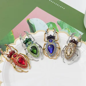 Detailed view of four punk style rhinestone beetle brooches in assorted vibrant colors