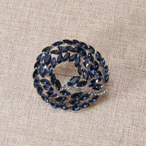 Nahaufnahme einer eleganten runden Brosche mit dunkelblauen Kristallen und Strass