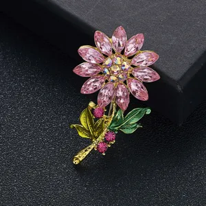 Detail van roze zonnebloem broche met strass steentjes kristallen bloemblaadjes en goud