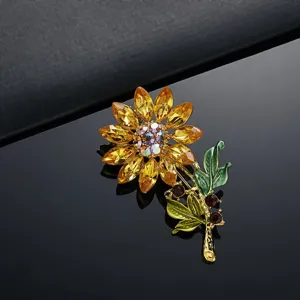 Prachtige zonnebloem broche met gele kristallen op een donker reflecterend oppervlak