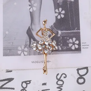 Primo piano di un'elegante spilla a ballerina dorata con tutu in strass scintillanti