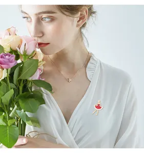 Elegante rode emaille ballerina broche op een witte jurk getoond in een close-up detailopname