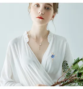 Detail van een elegante blauwe balletdanseres broche met strass op witte blouse