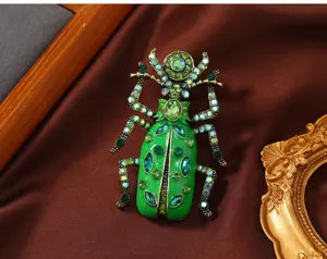 Detailaufnahme einer Vintage-Skarabäus-Brosche aus grüner Emaille mit Strasssteinen