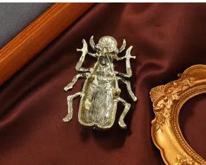 Rückansicht einer goldenen Vintage-Käfer-Brosche mit sicherem Nadelverschluss-Mechanismus