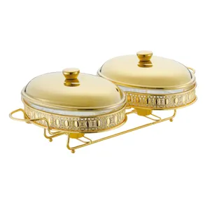 Double buffet food server with heat resistant glass bowls, gold metal stand and lids for catering.