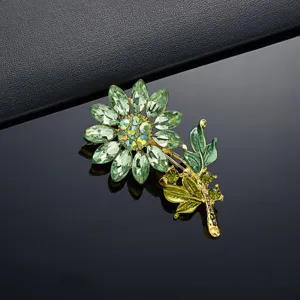Macrodetail van een groene strass zonnebloem broche met elegante gouden blaadjes