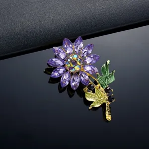 Gedetailleerd overzicht van een paarse strass zonnebloem broche met groene bladeren