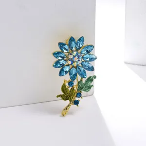 Detailopname van een blauwe zonnebloem broche met strass steentjes en emaille