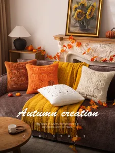 Detailansicht weicher Kissenbezüge mit Kürbisstickerei in gemütlicher Herbstszene