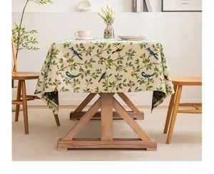 Vista dettagliata del motivo jacquard con fiori e uccelli su una tovaglia vintage color beige