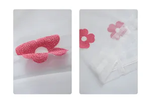 Detalle de la flor bordada rosa en la textura de malla de la cortina blanca pura