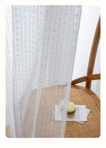 Detailaufnahme von weißem, französisch besticktem Voile-Vorhang mit Blumenmuster