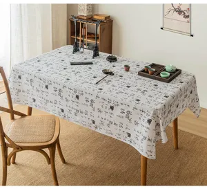 Dettaglio di tovaglia con stampa calligrafica cinese su tavolo da tè in legno.