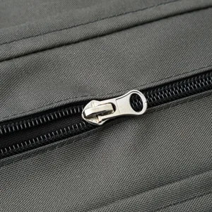 Primer plano de la cremallera metálica en funda de cojín exterior gris impermeable
