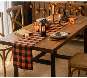 Detail view of orange and black buffalo plaid table runner in a festive Halloween room
