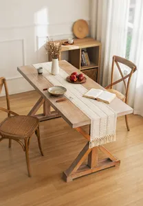 Detailed view of bohemian braided hemp table runner with tassels on wooden table